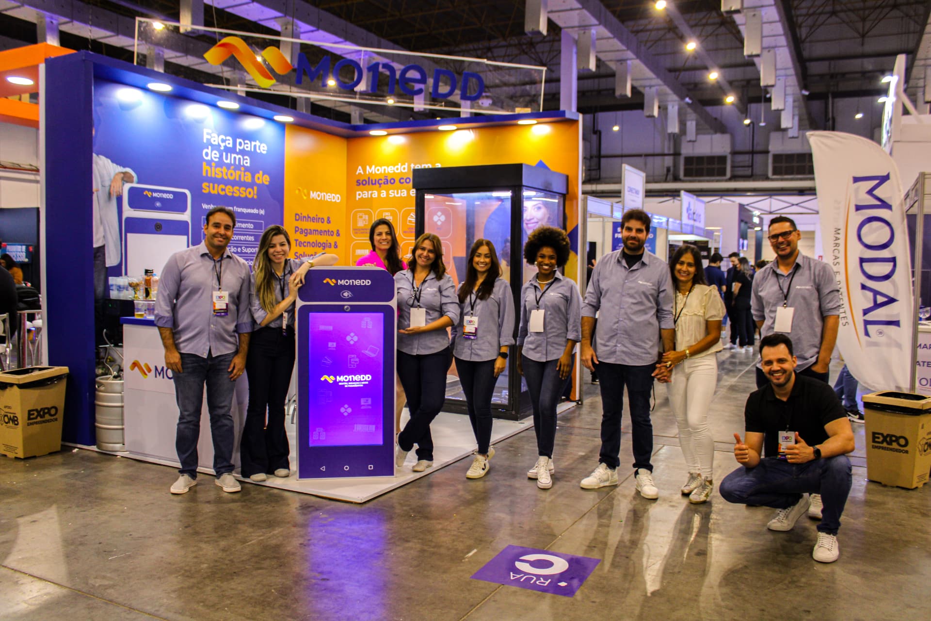 Estande da Monedd em feira de empreendedorismo com o time da empresa